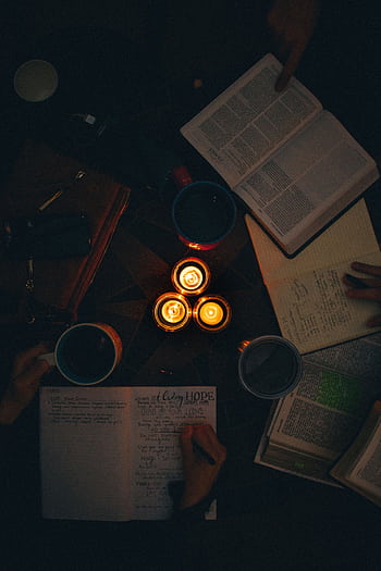 A moody, candle-lit study session with open books and notes, perfect for cozy learning vibes. HD phone wallpaper