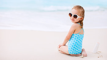 Beautiful Cute Little Girl Is Sitting On Beach Sand Wearing Blue White Dress Goggles In Blur Ocean Background Cute HD wallpaper