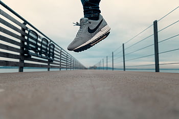 A close-up of a person jumping on a pier at Altnau, Switzerland, captured in motion. HD wallpaper