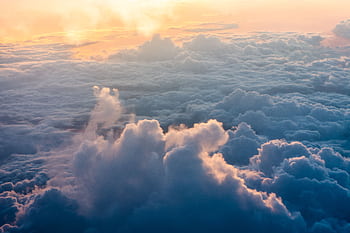 Stunning aerial view of sunlit clouds during sunrise, creating a tranquil and dramatic atmosphere. HD wallpaper