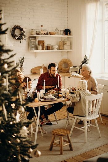Warm family gathering around a festive dinner table during the holiday season, sharing food and joy. HD phone wallpaper