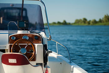 A yacht steering wheel with a serene water view during a bright summer day offering leisure and adventure. HD wallpaper