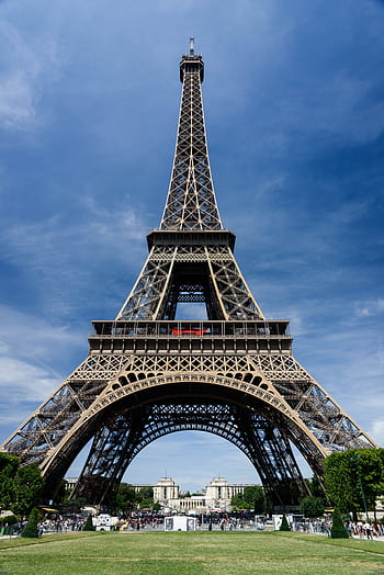 A striking view of the Eiffel Tower in Paris under a brilliant blue sky, capturing its architectural grandeur. HD phone wallpaper