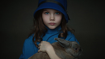 Cute Little Girl With Rabbit Is Wearing Blue Dress And Hat Standing In Dark Background Cute HD wallpaper