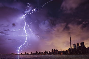 A striking lightning bolt illuminates the Toronto skyline against a dramatic stormy sky. HD wallpaper