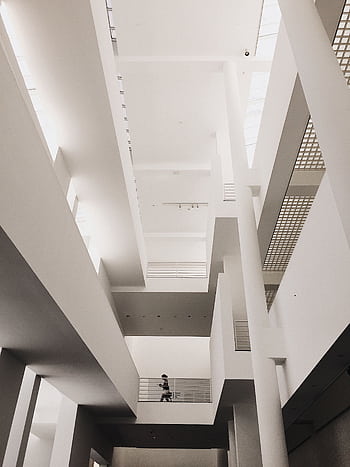 Low angle shot of a minimalist, modern interior with a person walking, great for architectural concepts. HD phone wallpaper