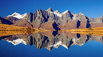 Majestic mountains reflected in Zupalsee with cyclists, Tirol, Austria. HD wallpaper