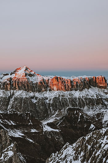 Breathtaking view of the Dolomites during sunrise with snow-capped peaks and a serene sky. HD phone wallpaper