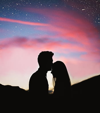 Silhouetted couple sharing an intimate moment against a colorful twilight sky. HD phone wallpaper