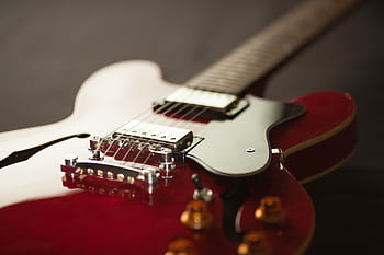 Detailed close-up of a red electric guitar showcasing the bridge and strings. HD wallpaper