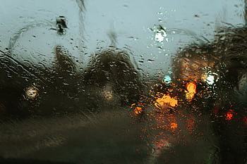 Abstract view of a rainy city street through a wet window with colorful blurry lights. HD wallpaper