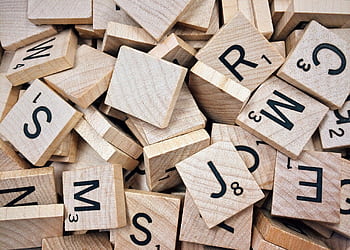 A collection of wooden Scrabble tiles with letters and numbers stacked randomly. HD wallpaper