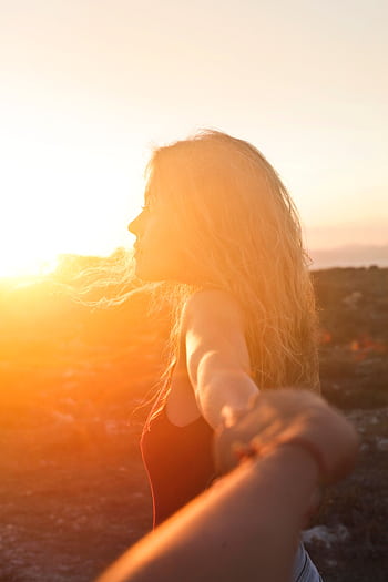 A woman enjoys a serene moment in Malta's golden sunset, embracing nature and dom. HD phone wallpaper