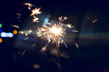 A vibrant sparkler lighting up the night, perfect for celebrations and festive occasions. HD wallpaper