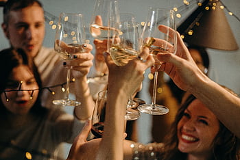 A group of friends joyfully toasting with champagne glasses at a festive celebration. HD wallpaper