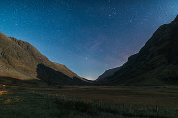 A breathtaking view of a starry night over a mountain valley, capturing the serene beauty of nature. HD wallpaper
