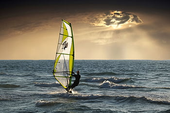 Exciting windsurfing action against a dramatic sunset seascape. Perfect for adventure and travel themes. HD wallpaper