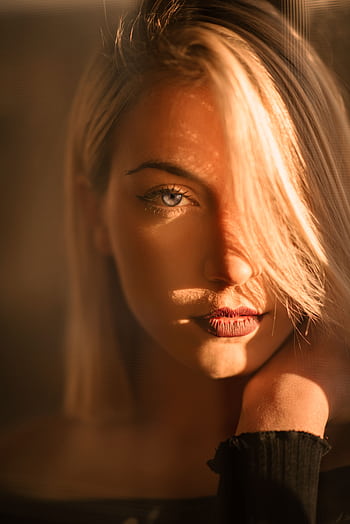 Captivating portrait of a blonde woman bathed in warm golden hour light. HD phone wallpaper