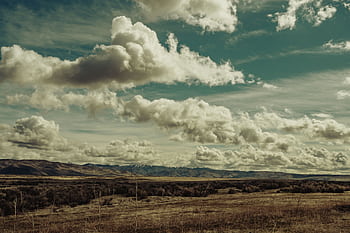 A breathtaking scenery with clouds over a vast mountain range, capturing nature's beauty. HD wallpaper