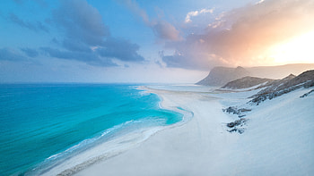 Beautiful Ocean View Waves White Beach Sand Mountains With Fog Under Blue Sky Nature HD wallpaper