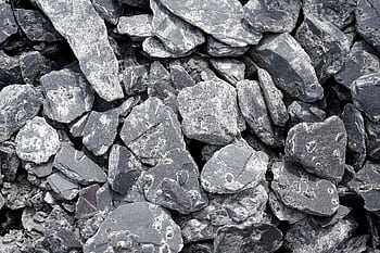 A detailed and textured close-up of natural slate rocks showcasing rough surfaces and variations. HD wallpaper