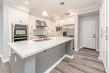 Modern kitchen interior featuring sleek white cabinetry and stainless steel appliances. HD wallpaper