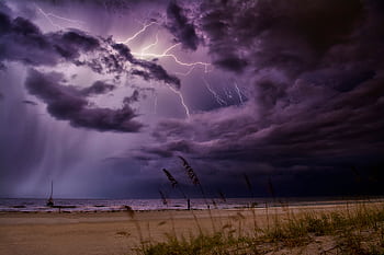 Dramatic lightning bolts illuminate the night sky over Redington Beach, creating a stunning natural scene. HD wallpaper