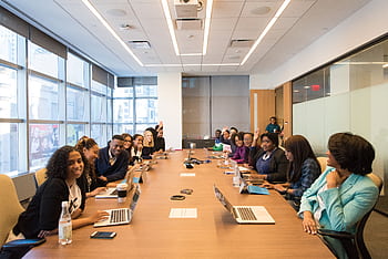 A diverse group of professionals engaging in a productive meeting around a conference table. HD wallpaper