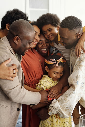 Heartwarming family group hug showcasing affection and togetherness indoors. HD phone wallpaper