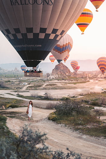 Hot air balloons soar above Cappadocia's unique landscape during a stunning sunrise. HD phone wallpaper