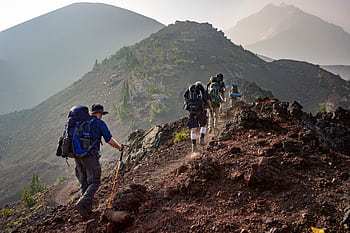 Group of hikers trekking on a rugged mountain trail in Oregon's scenic outdoors. HD wallpaper