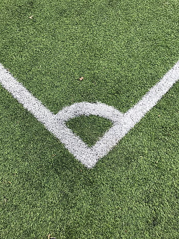 Detailed close-up of a white corner line on a green soccer field turf. HD phone wallpaper
