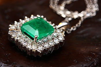Stunning emerald pendant necklace in white gold with shimmering diamonds, epitomizing luxury and elegance. HD wallpaper