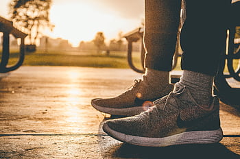 Close-up of sneakers on person standing outdoors at sunrise in a Chicago park. HD wallpaper