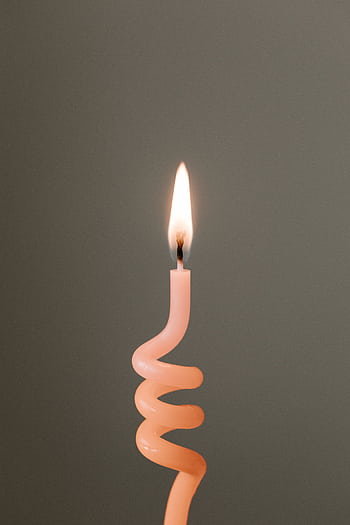 Close-up of a lighted spiral candle with a flame against a neutral background. HD phone wallpaper