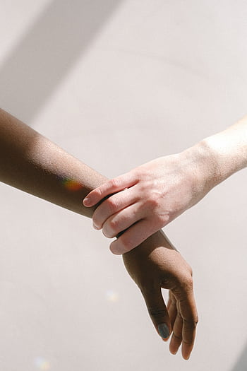 Close-up of diverse hands clasped together, symbolizing unity and support. HD phone wallpaper