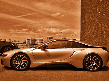Sleek luxury sports car parked outdoors, highlighted in sepia tone for an artistic touch. HD wallpaper