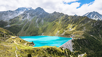 Lake Surrounded By Greenery Mountains Slope In White Clouds Blue Sky Background Nature HD wallpaper