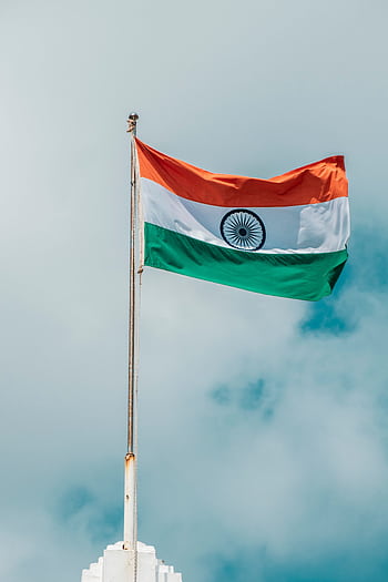 The Indian national flag waving proudly against a cloudy blue sky in Puducherry. HD phone wallpaper