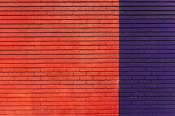 Bold red and purple brick wall creating a striking visual texture with strong linear patterns. HD wallpaper