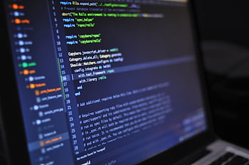 Close-up of a computer screen displaying programming code in a dark environment. HD wallpaper