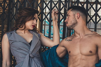 A fashionable couple posing in an edgy urban setting, showcasing style and romance. HD wallpaper