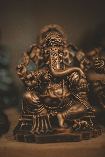 Elegant bronze Ganesha statue displaying intricate craftsmanship, highlighting cultural and spiritual significance. HD phone wallpaper