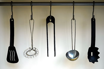 A set of stainless steel and plastic kitchen utensils hanging on a rail. HD wallpaper