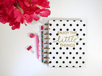 Flat lay of polka dot notebook, flowers, and stationery on white desk. HD wallpaper