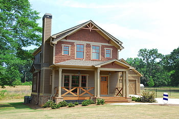 Charming single-family home with a porch, lawn, and trees, ideal for real estate use. HD wallpaper