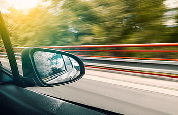 Side mirror view capturing high-speed travel on an expressway with motion blur effect. HD wallpaper