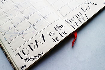 Open planner with handwritten quotes and calendar layout, promoting positivity and organization. HD wallpaper