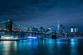 Stunning night view of the illuminated Brooklyn Bridge and New York City skyline across the water. HD wallpaper