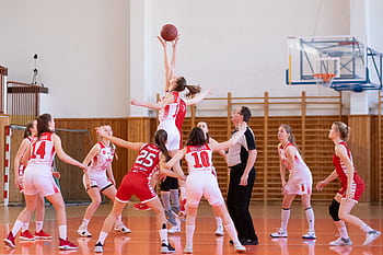 Exciting women's basketball game in a school gym, showcasing teamwork and athleticism. HD wallpaper